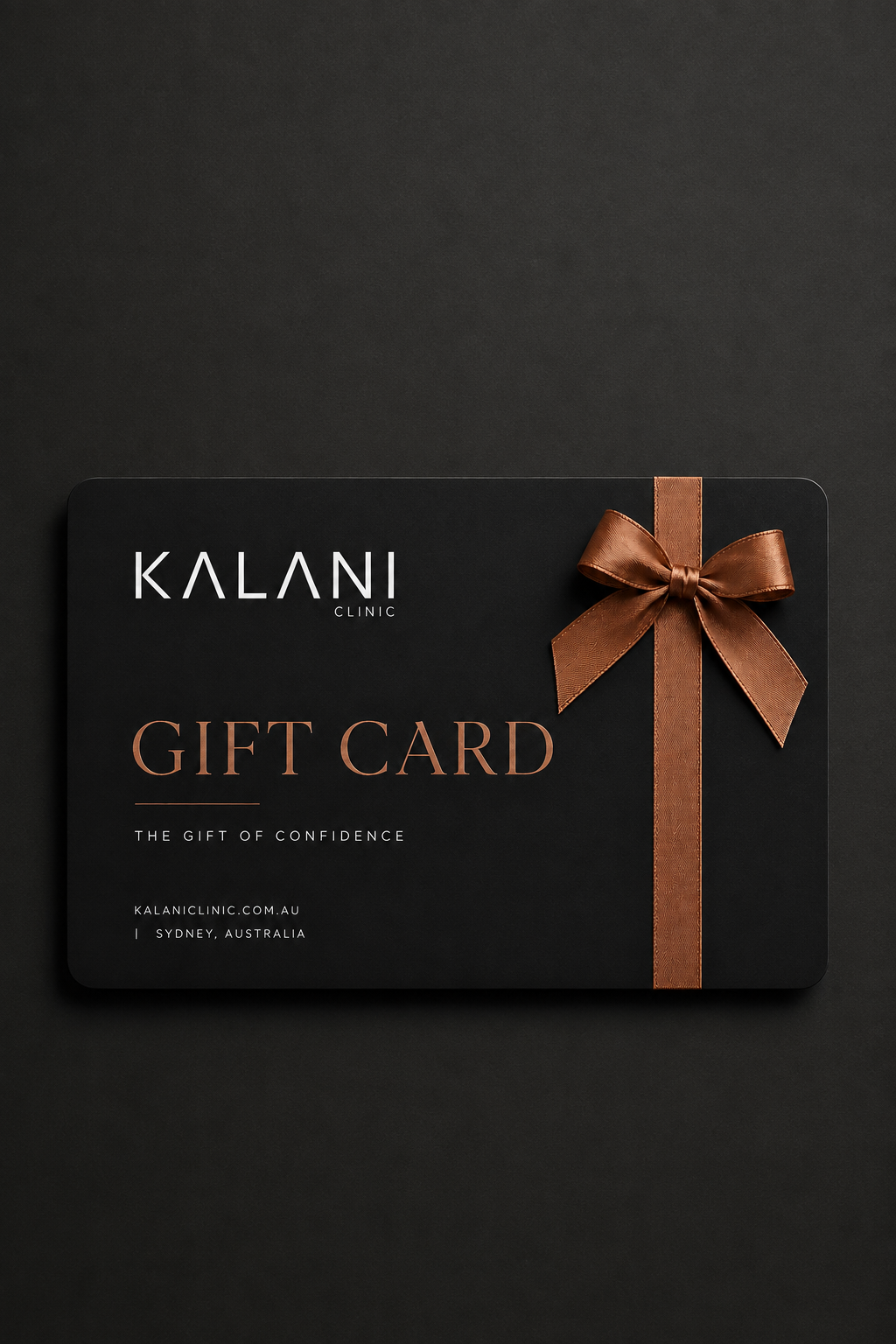 A black gift card for Kalani Clinic with elegant gold lettering and a brown ribbon bow on the right side, presented on a dark textured background.